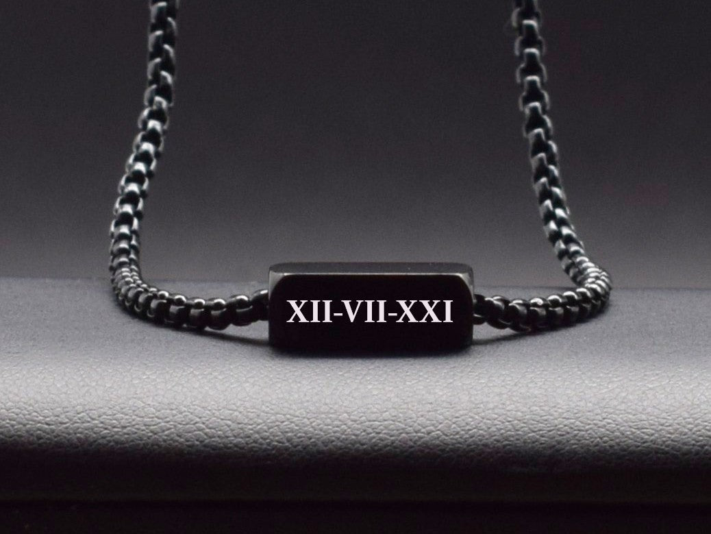 Black rectangular pendant with custom Roman numerals on a black chain 